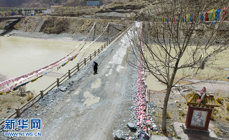 4月22日，尼瑪才讓老人通天河大橋上行走。新華社 吳剛 攝