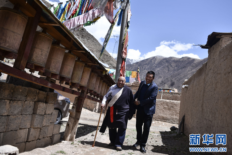 4月22日，陳林巴?。ㄓ遥┡愀赣H尼瑪才讓在村子內(nèi)轉(zhuǎn)寺院。新華社 吳剛 攝