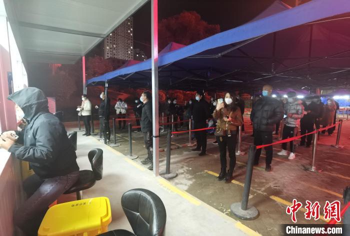 圖為核酸采集窗口前排隊等候的市民?！∨擞隄?攝