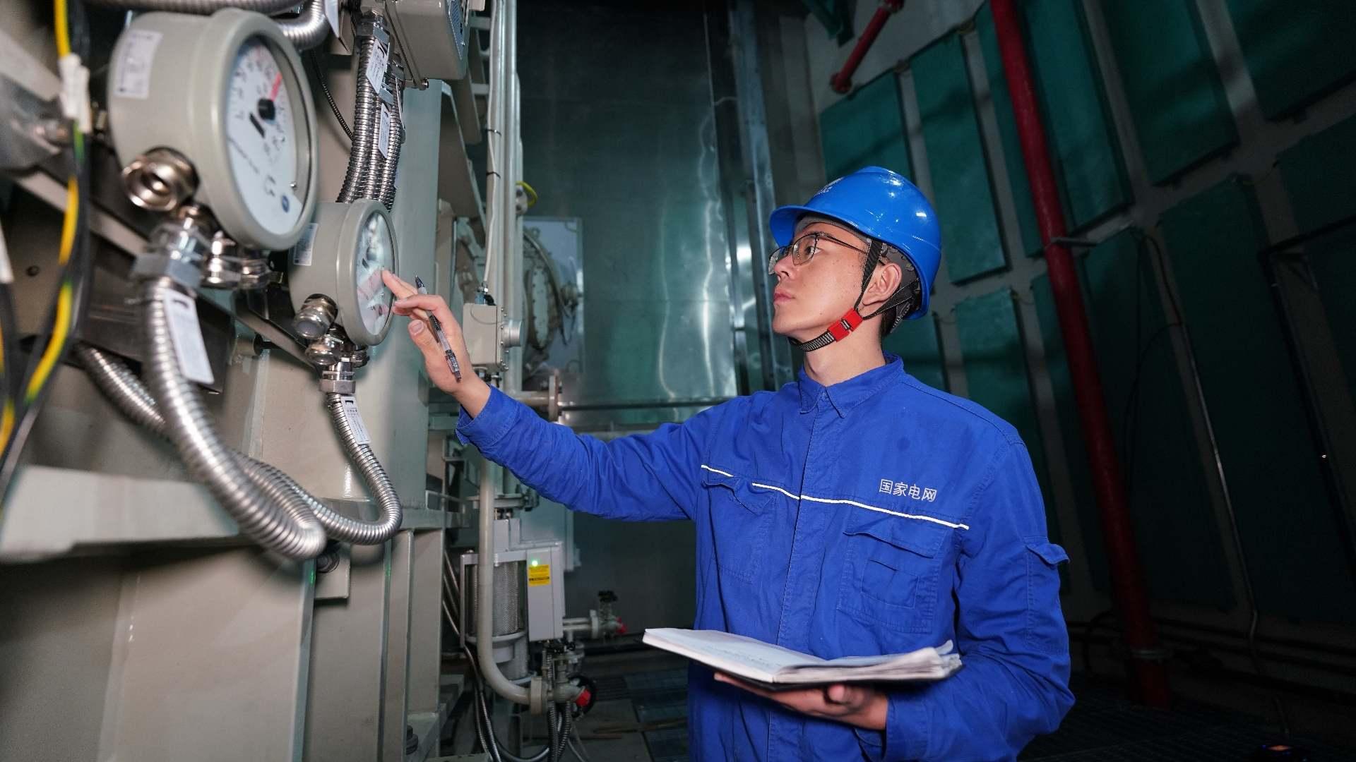 國(guó)網(wǎng)四川電力藏族員工次爾杜吉在布拖換流站檢查油表。鄭自豪攝